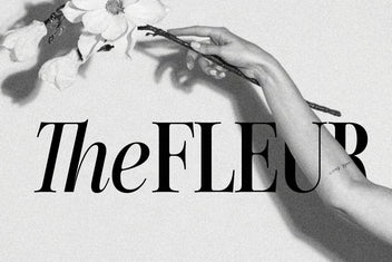 The word "TheFLEUR" set in The Silver Editorial, mixing italic and roman caps, beside a hand holding a magnolia branch in black and white.