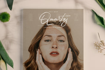 Dreaming of Spring script on a Quartz magazine cover over a freckled woman with hands to her face