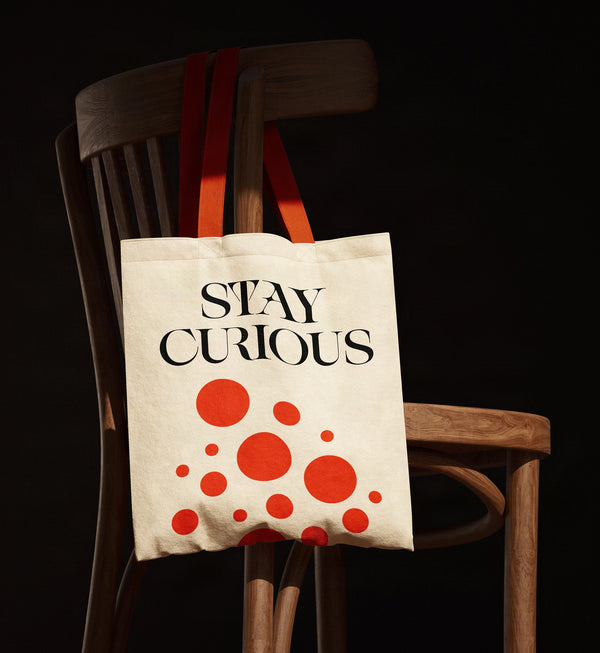 Stay Curious tote bag print in SLTF Spanish Archer with red dots on a wooden chair